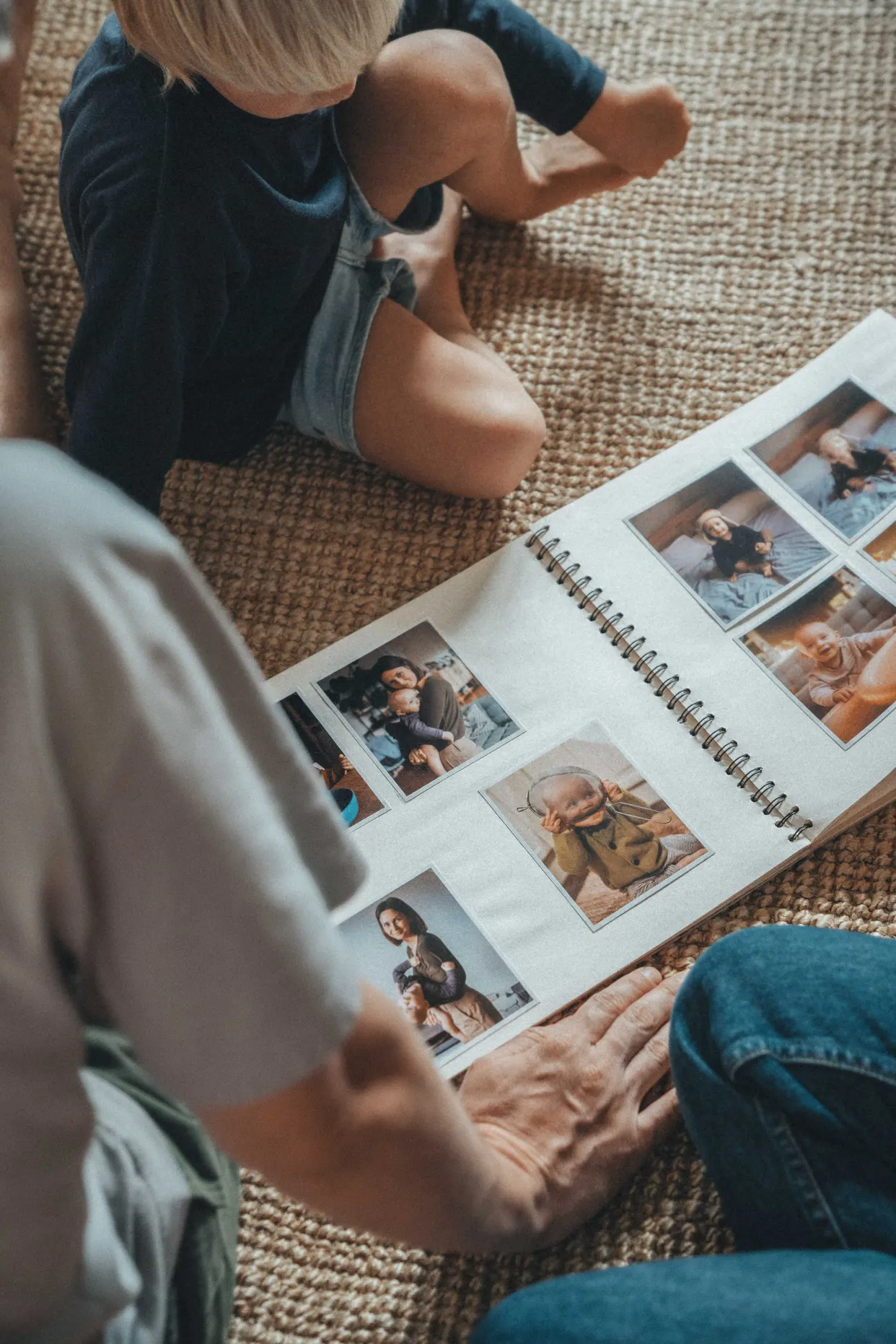 Adulto e criança folheando um álbum de fotos de família impressas